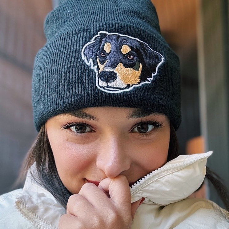 Young woman wearing a personalized black cuff beanie with her dog embroidered on the front.