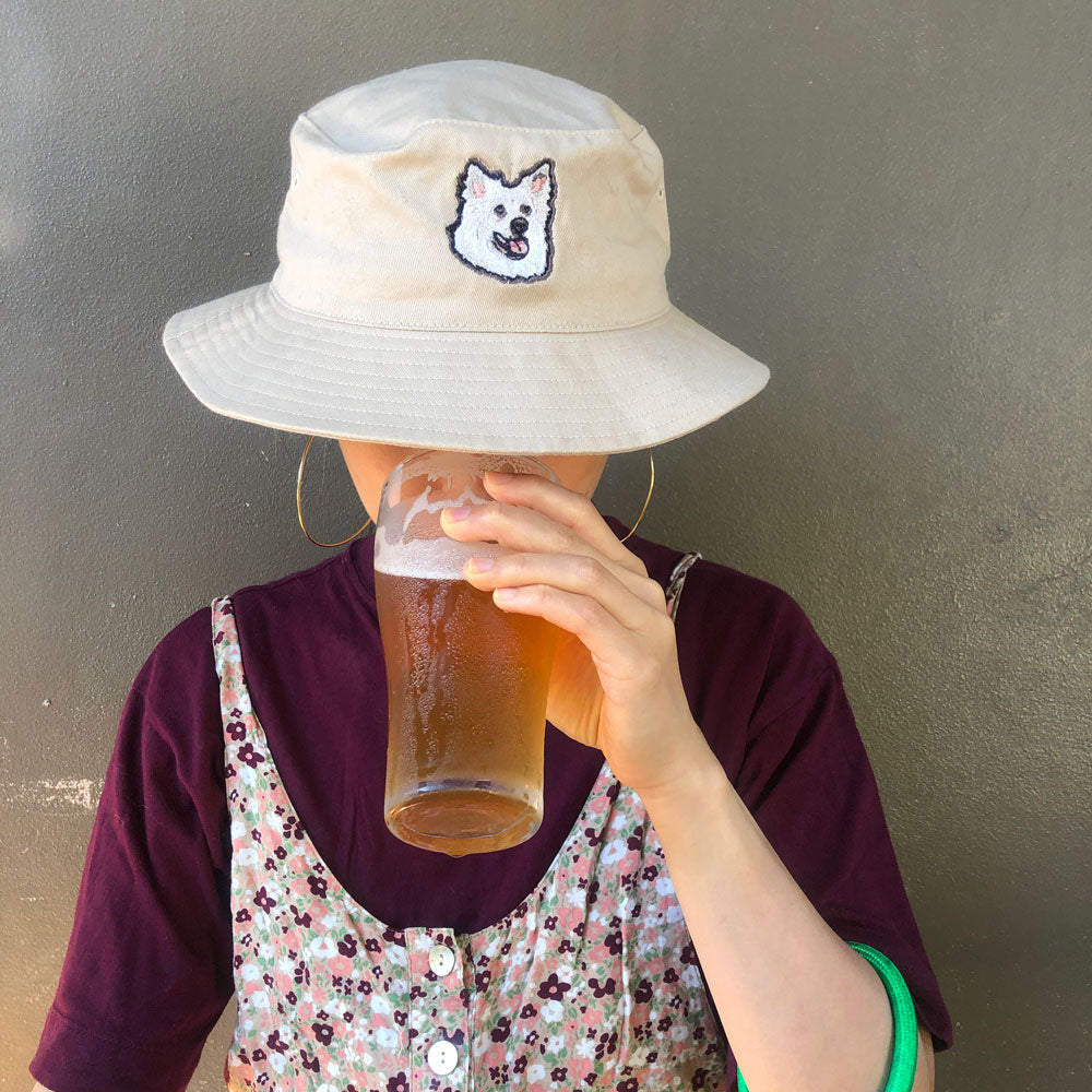 Tan custom dog bucket hat for dog moms and dog dads with a pet's face embroidered on the front.