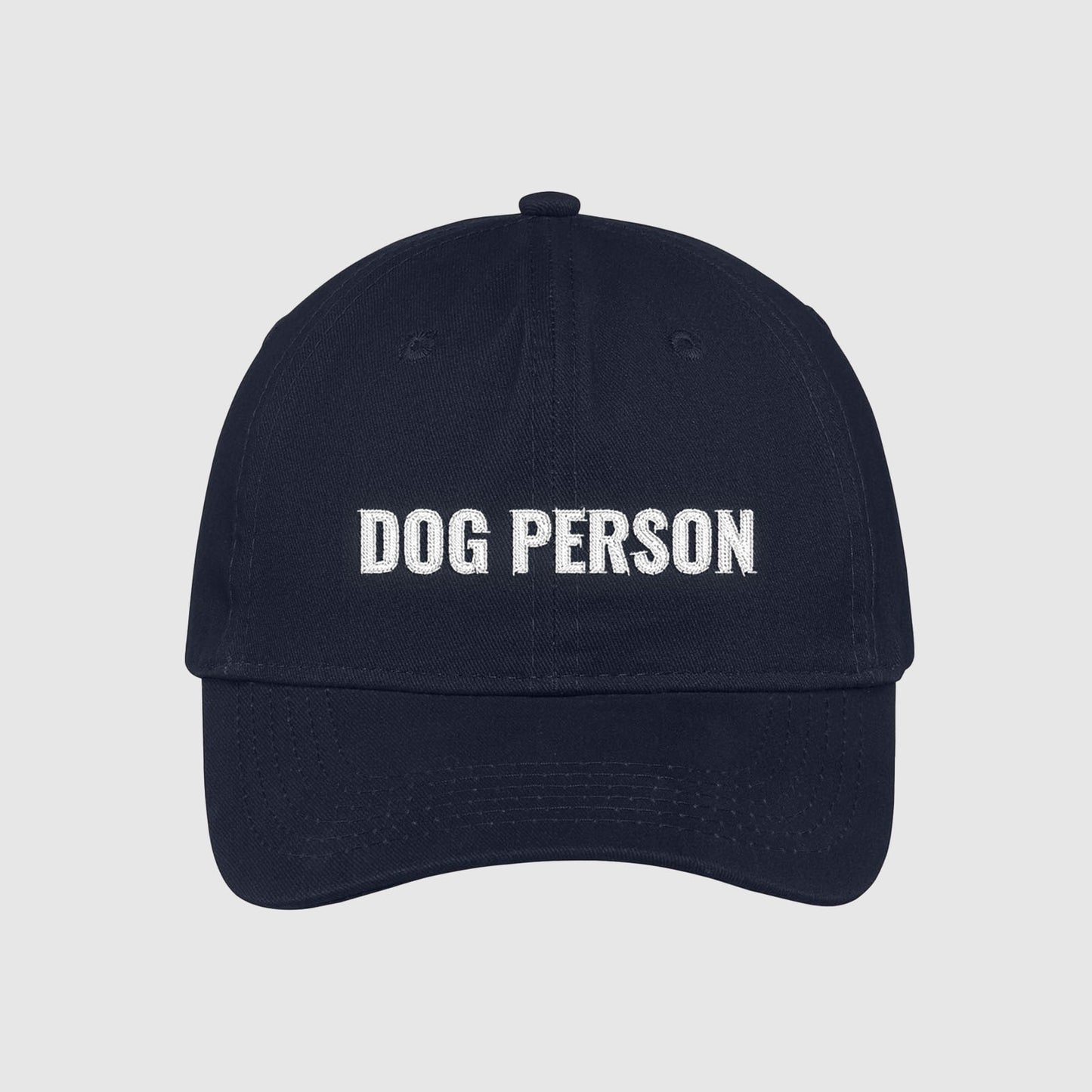 Navy dad hat with Dog Person embroidered on the front with white thread.